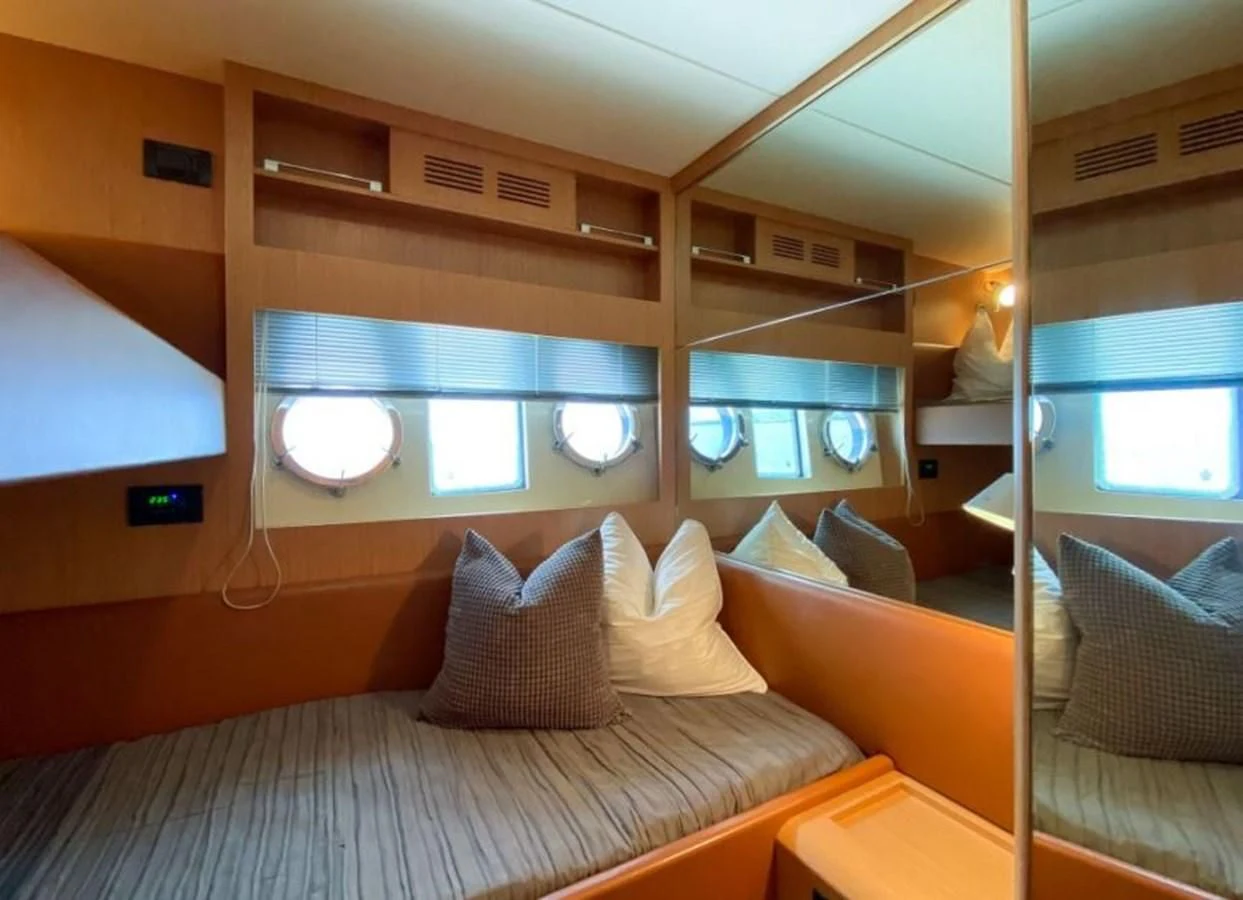 a bed with a white bed spread aboard HEADQUARTERS Yacht for Sale