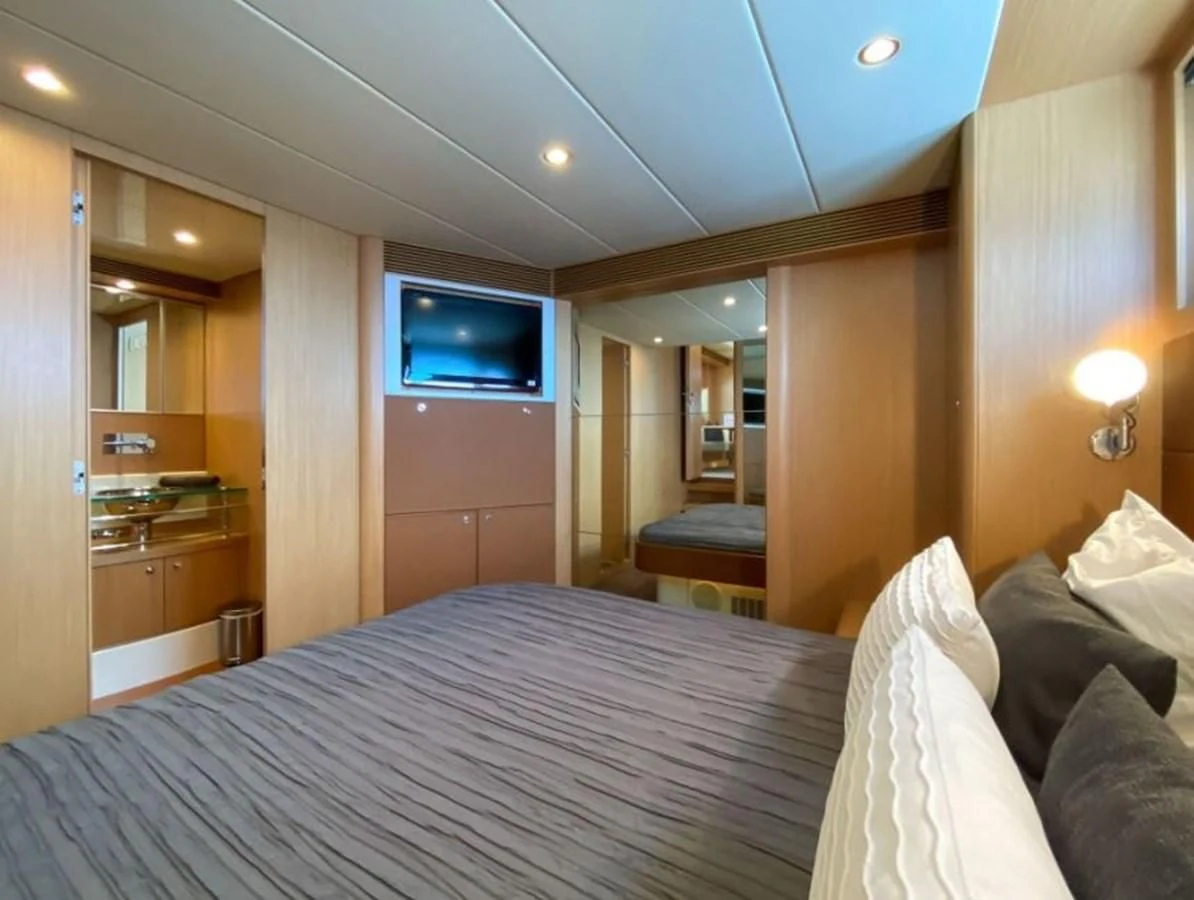 a bedroom with a bed and a tv aboard HEADQUARTERS Yacht for Sale