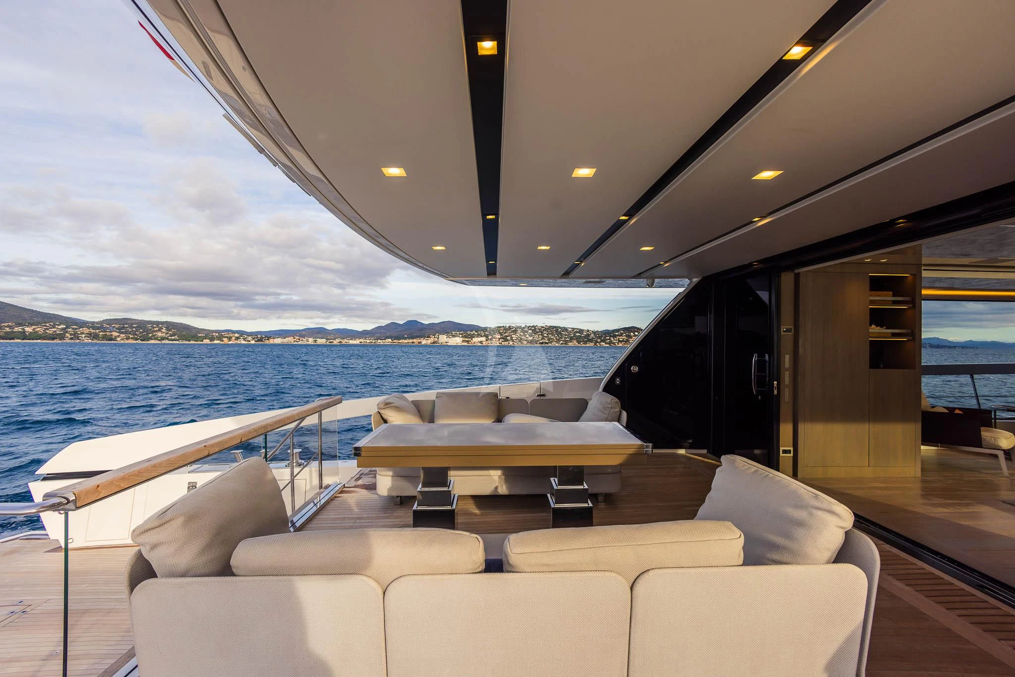 a boat with a view of the ocean and mountains aboard VINCI II Yacht for Sale
