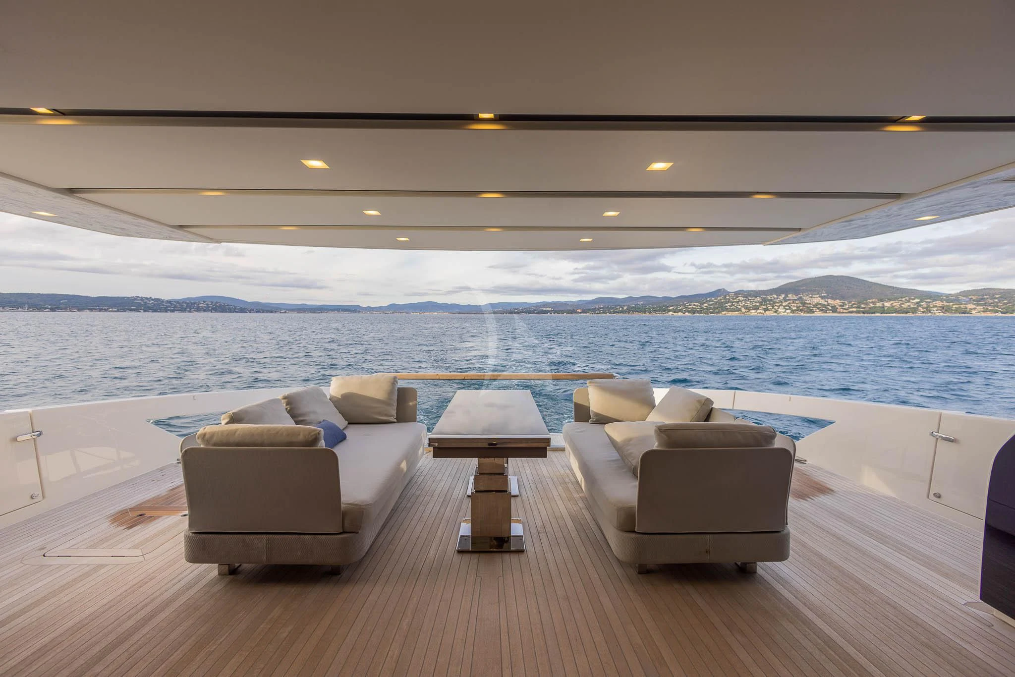 a room with a couch and a large body of water in the background aboard VINCI II Yacht for Sale