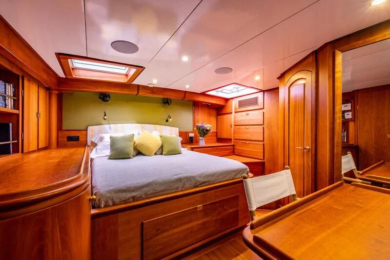 a room with a bed and desk aboard BOLERO Yacht for Sale