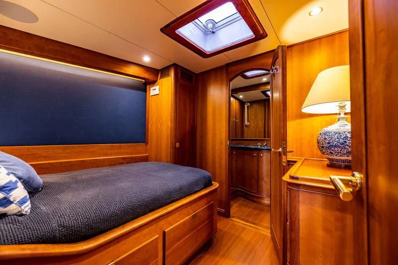 a bedroom with a bed and a lamp aboard BOLERO Yacht for Sale
