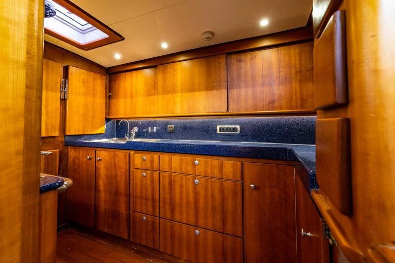 a kitchen with wooden cabinets aboard BOLERO Yacht for Sale