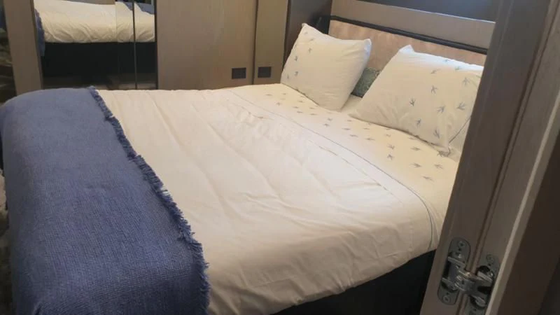 a bed with white sheets aboard HANAVA Yacht for Sale