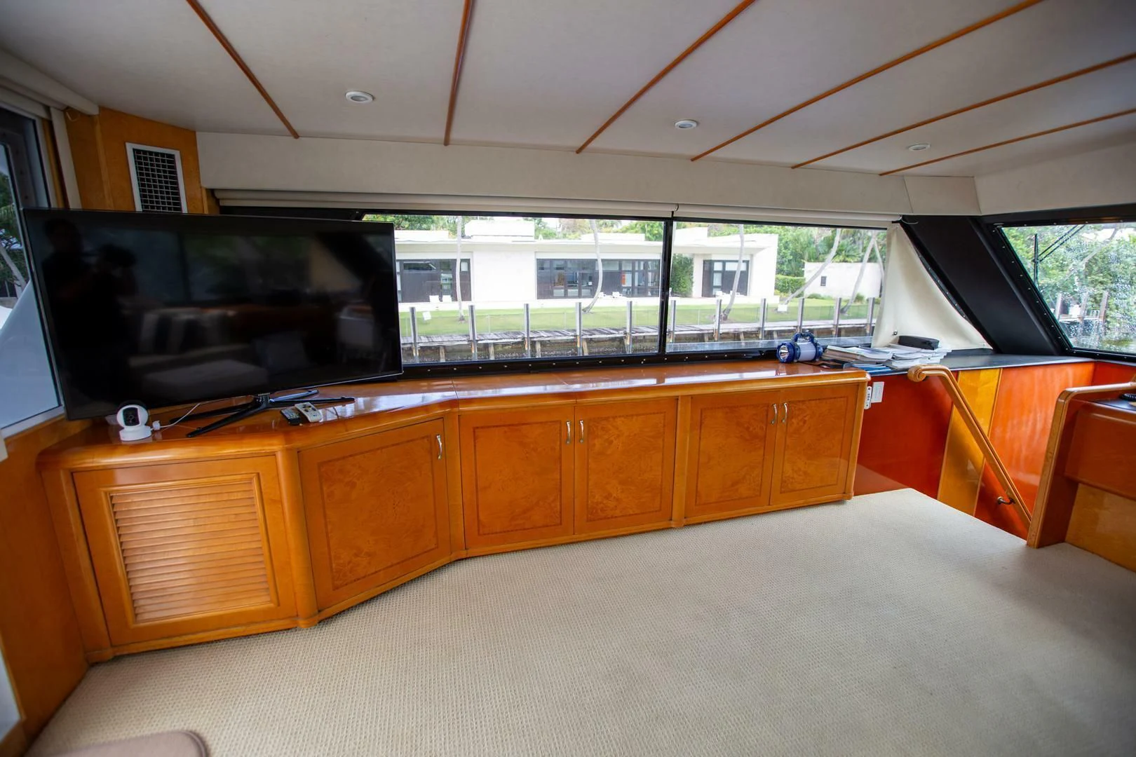 a room with a tv and wooden cabinets aboard PAINKILLER Yacht for Sale