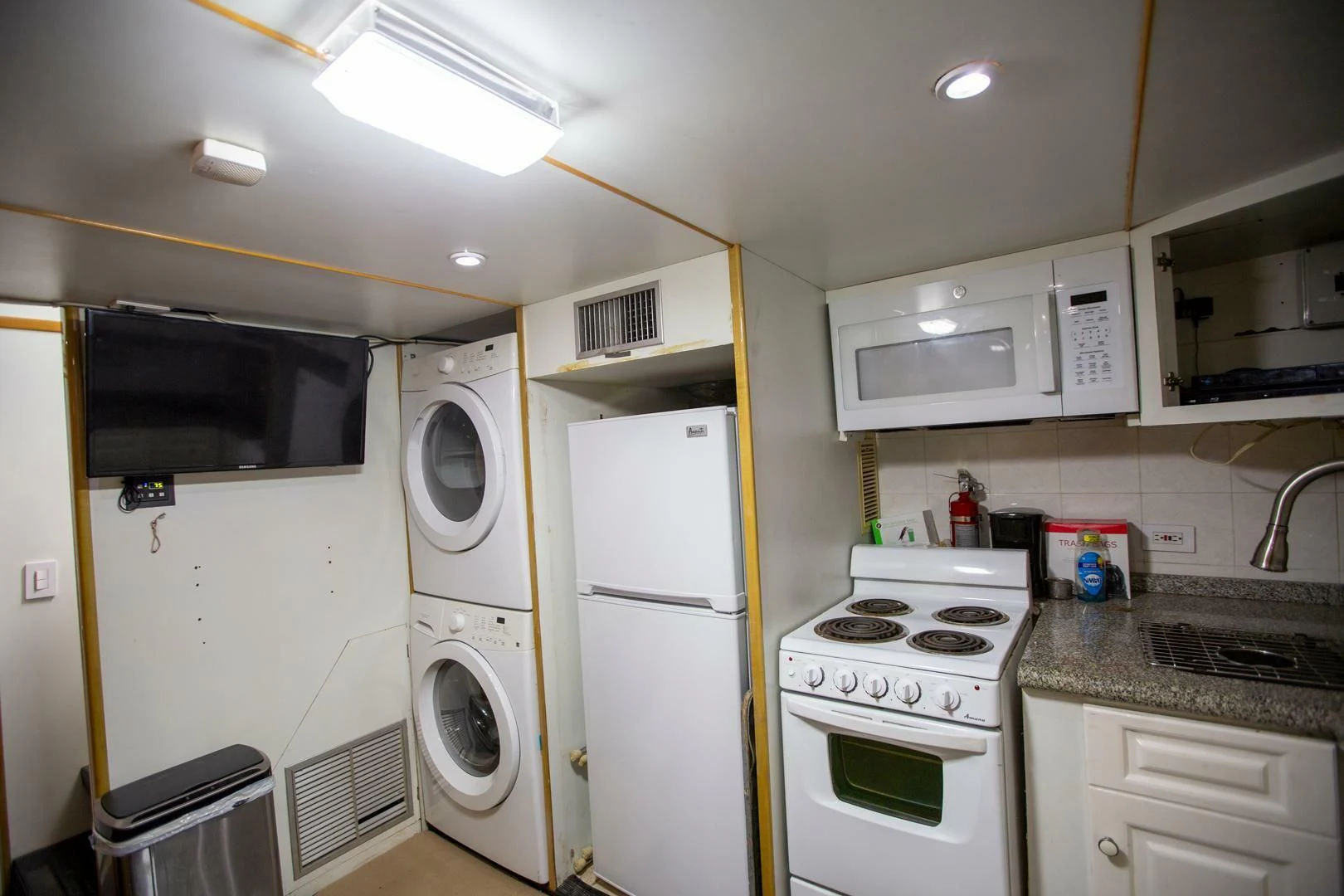 a kitchen with white appliances aboard PAINKILLER Yacht for Sale