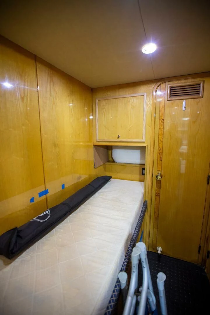 a room with a wood wall and a bed and a door aboard PAINKILLER Yacht for Sale