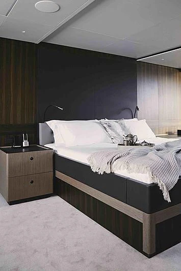 a bedroom with a bed and a desk aboard BACCHANAL Yacht for Sale