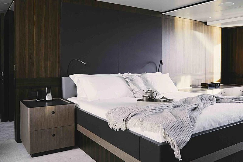 a bedroom with a bed and a dresser aboard BACCHANAL Yacht for Sale