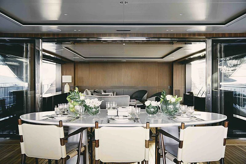 a table with white chairs and white tables aboard BACCHANAL Yacht for Sale