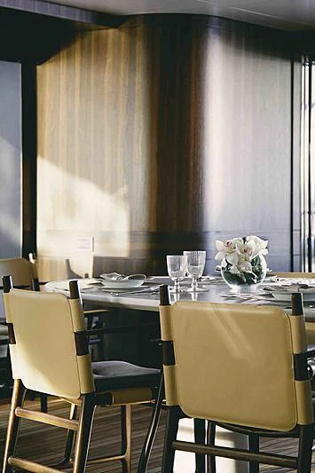 a table with chairs and flowers aboard BACCHANAL Yacht for Sale