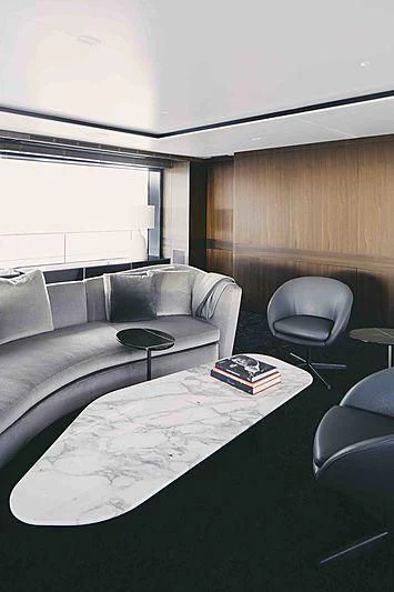 a couch and a table in a room aboard BACCHANAL Yacht for Sale