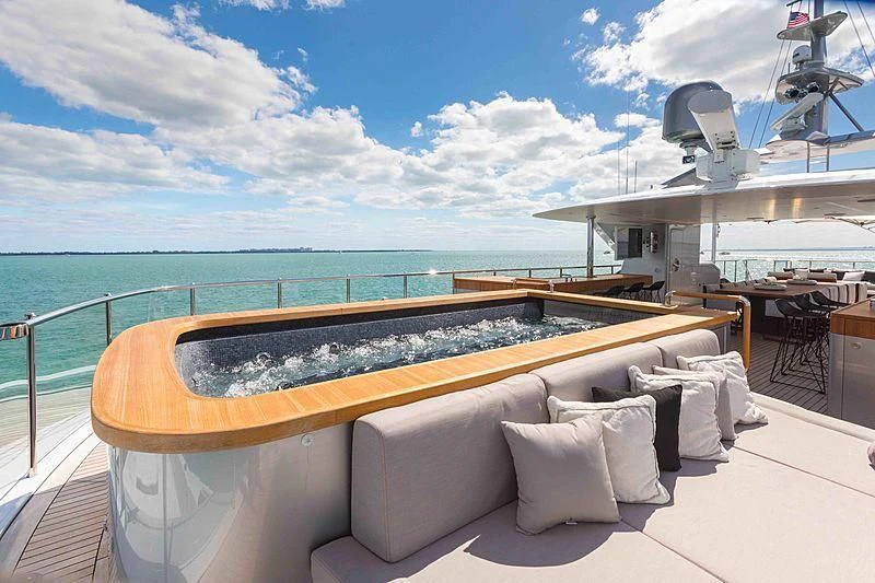 a lounge chair on a deck overlooking the ocean aboard BACCHANAL Yacht for Sale
