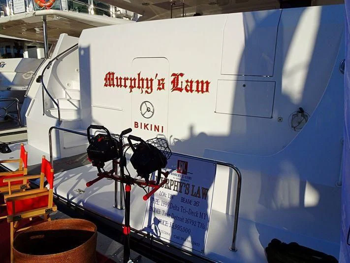 a white boat with a black and red stripe aboard MURPHY'S LAW Yacht for Charter