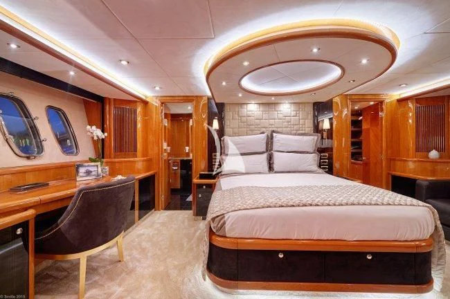a bedroom with a bed and a desk aboard PEARL OF LONDON Yacht for Sale