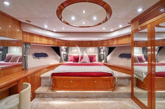 a room with a bed and a mirror aboard PEARL OF LONDON Yacht for Sale