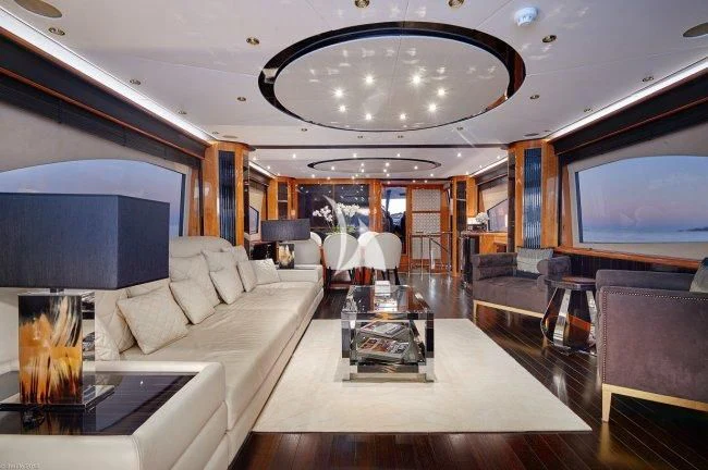 a living room with a large chandelier aboard PEARL OF LONDON Yacht for Sale