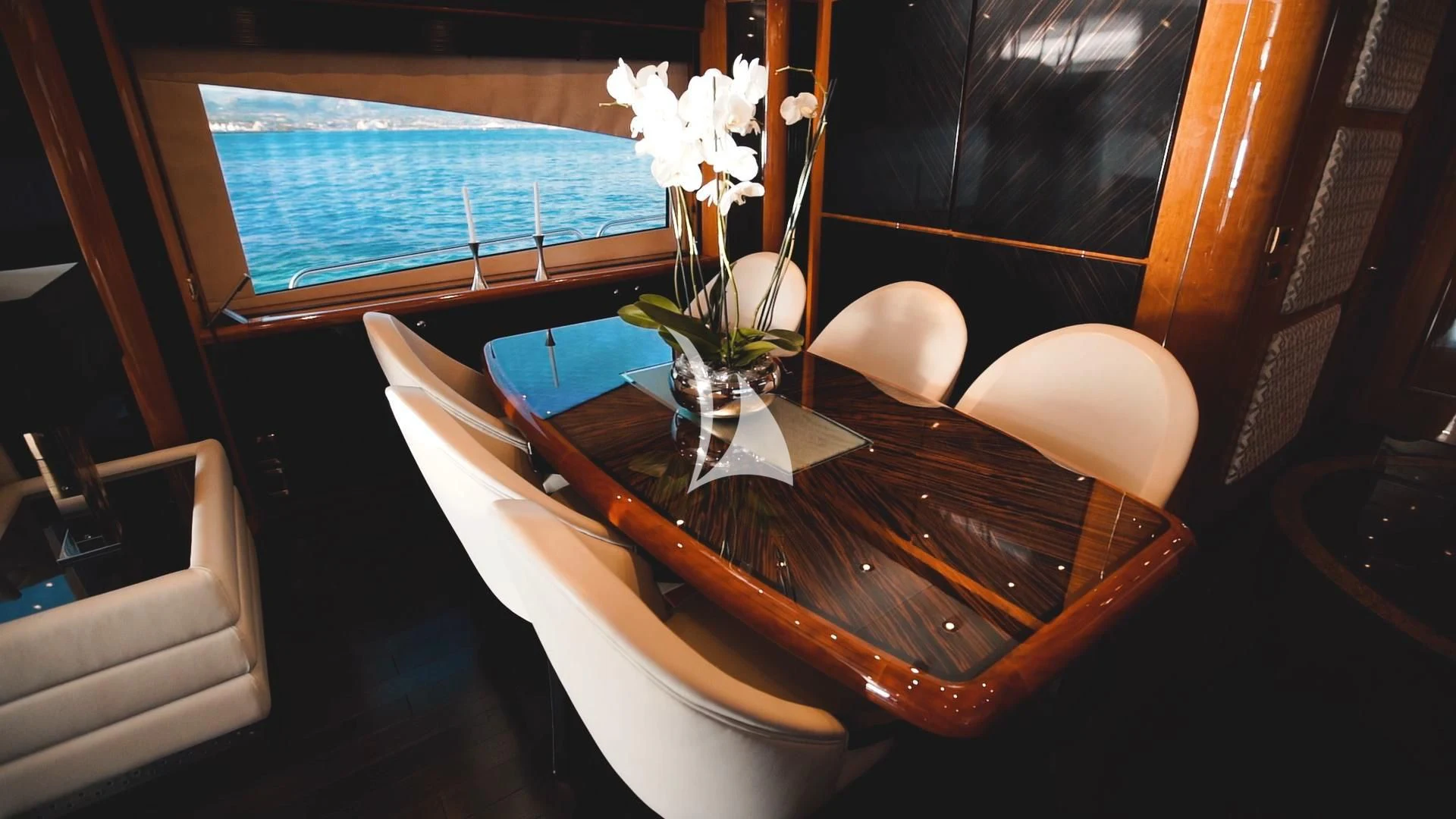 a table with chairs and a vase with flowers on it aboard PEARL OF LONDON Yacht for Sale