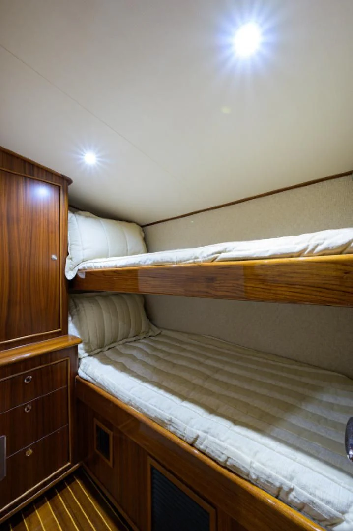 a bedroom with a bed and a dresser aboard FLYING J Yacht for Sale