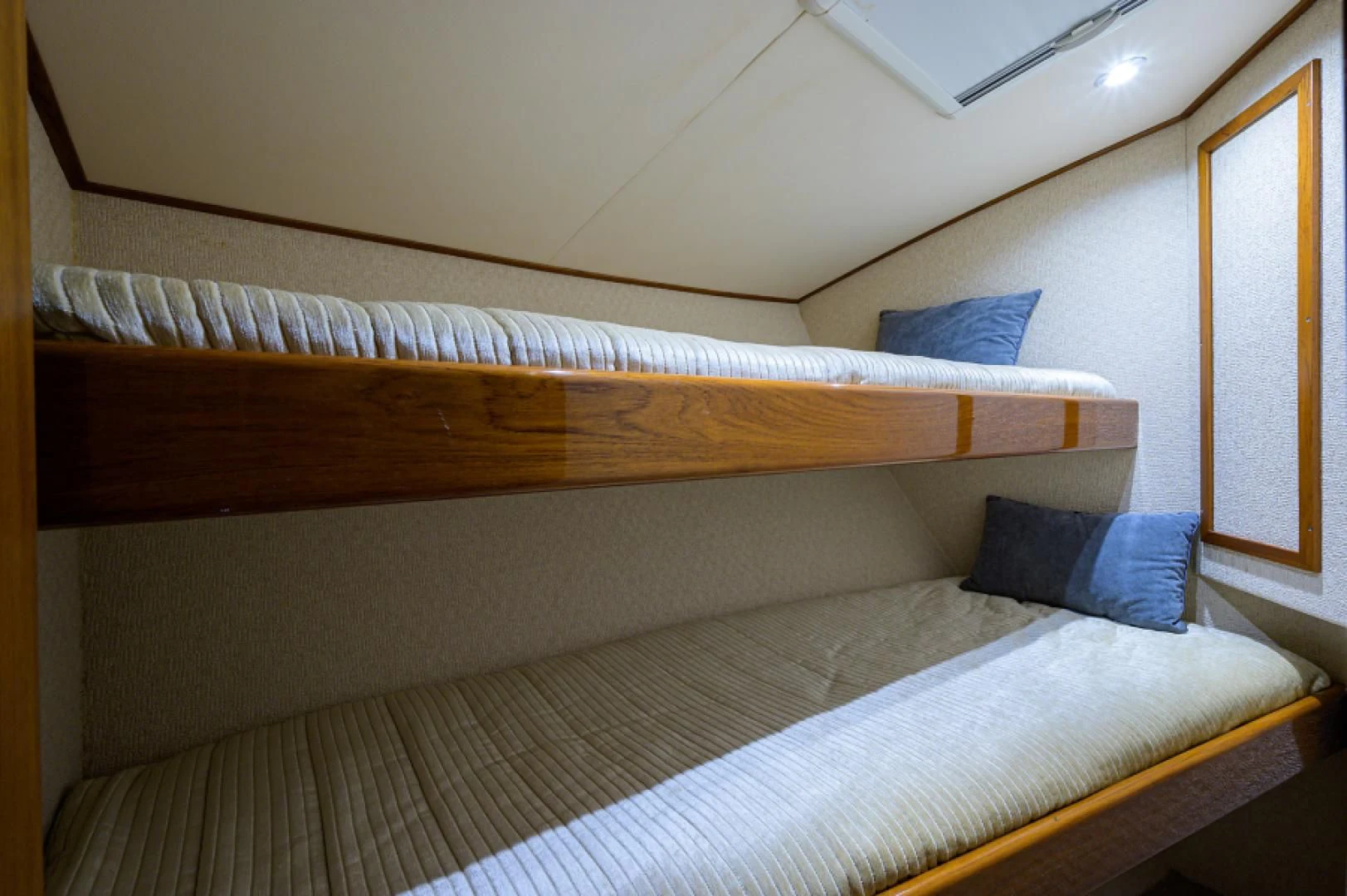 a bed with a wooden headboard aboard FLYING J Yacht for Sale