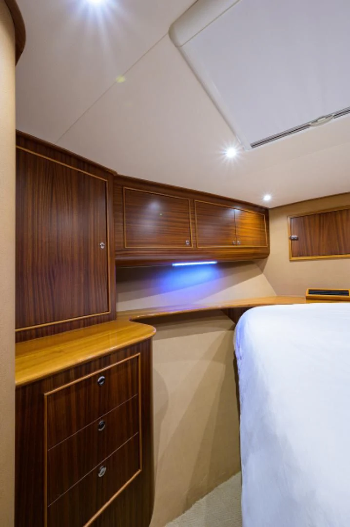 a bedroom with a bed and a dresser aboard FLYING J Yacht for Sale