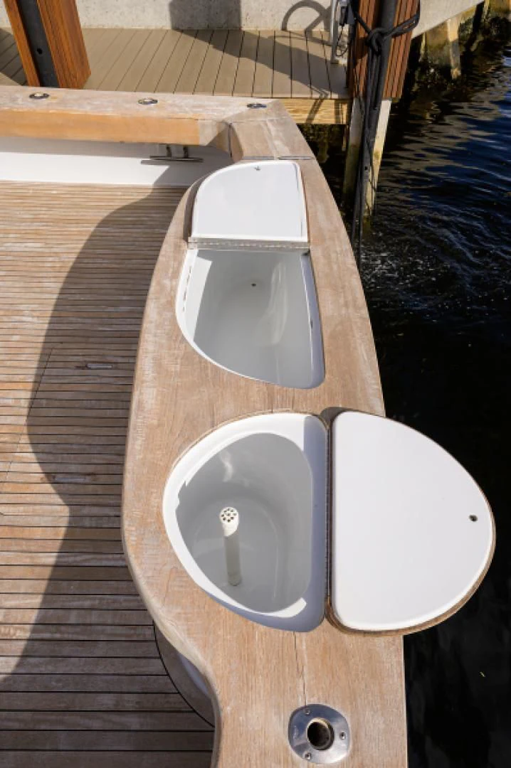 a row of white plates on a wooden table aboard FLYING J Yacht for Sale