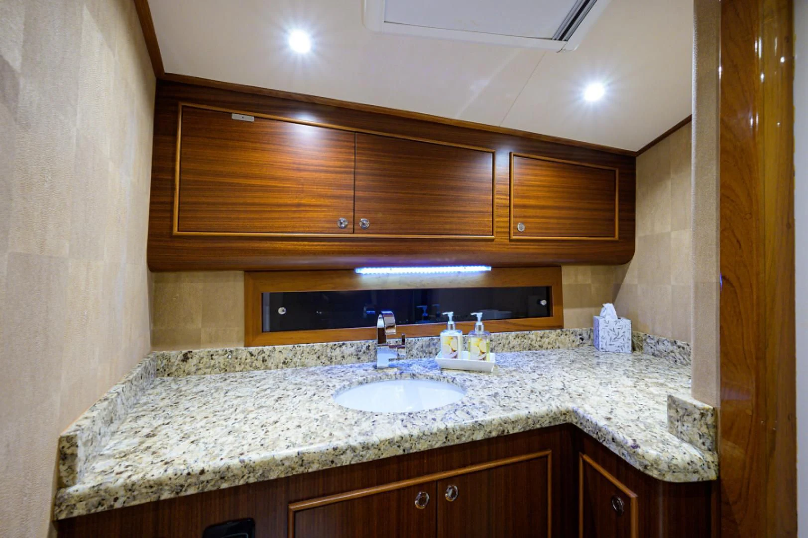 a bathroom with a countertop sink and wooden cabinets aboard FLYING J Yacht for Sale