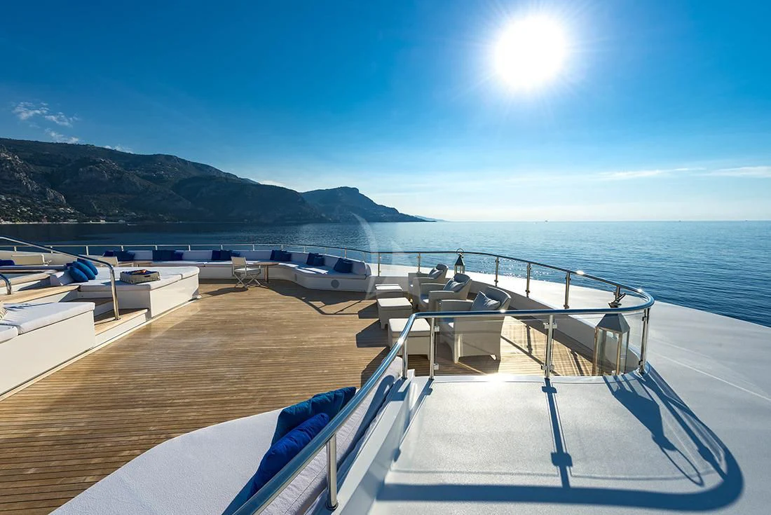 a deck with a view of the ocean and mountains in the background aboard MARQUISE Yacht for Sale