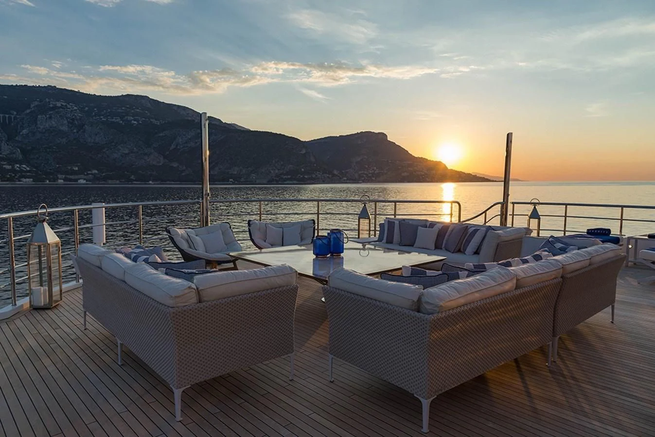a deck with a view of the sunset and mountains in the background aboard MARQUISE Yacht for Sale