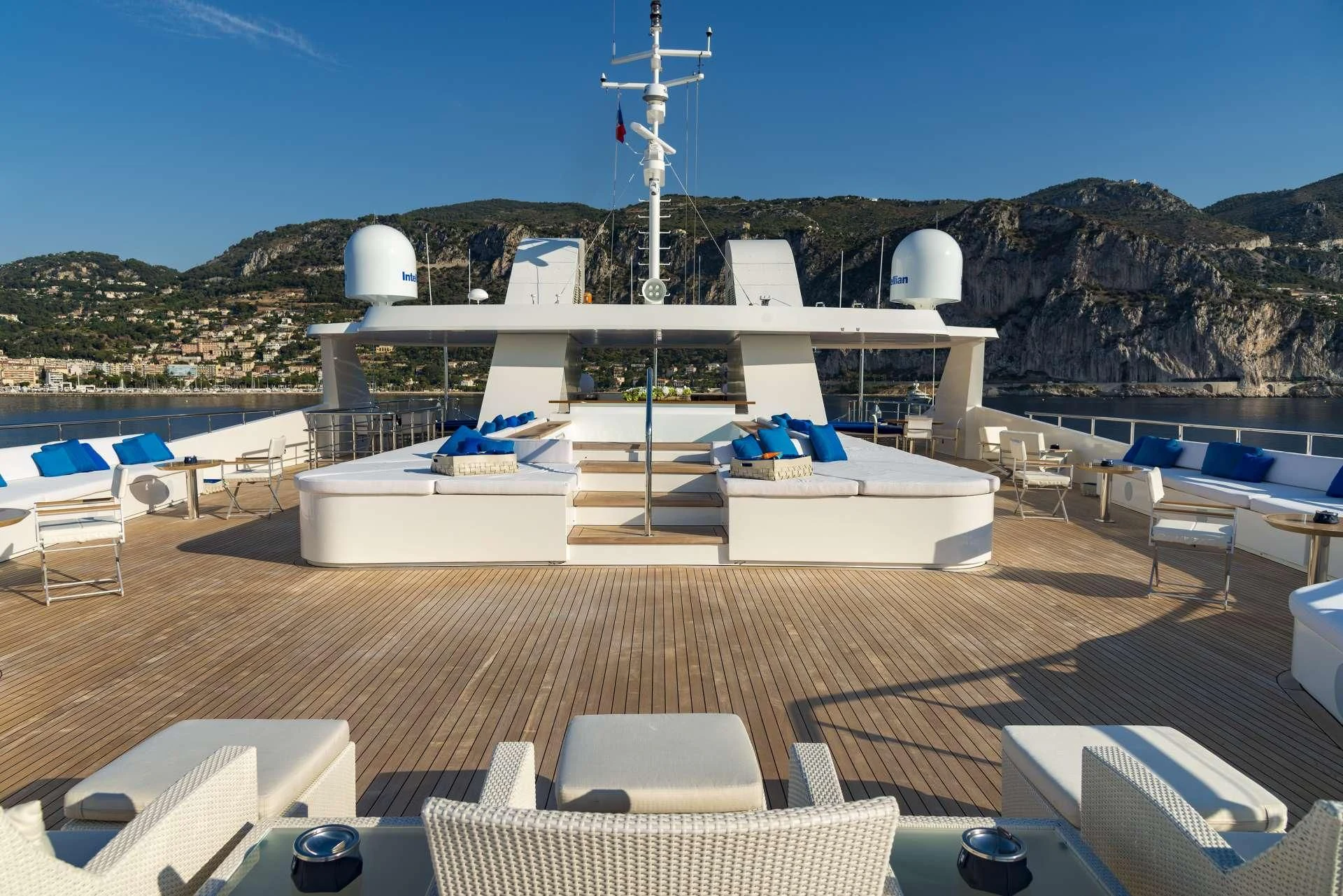 a deck with a pool and a large building with a tower in the background aboard MARQUISE Yacht for Sale