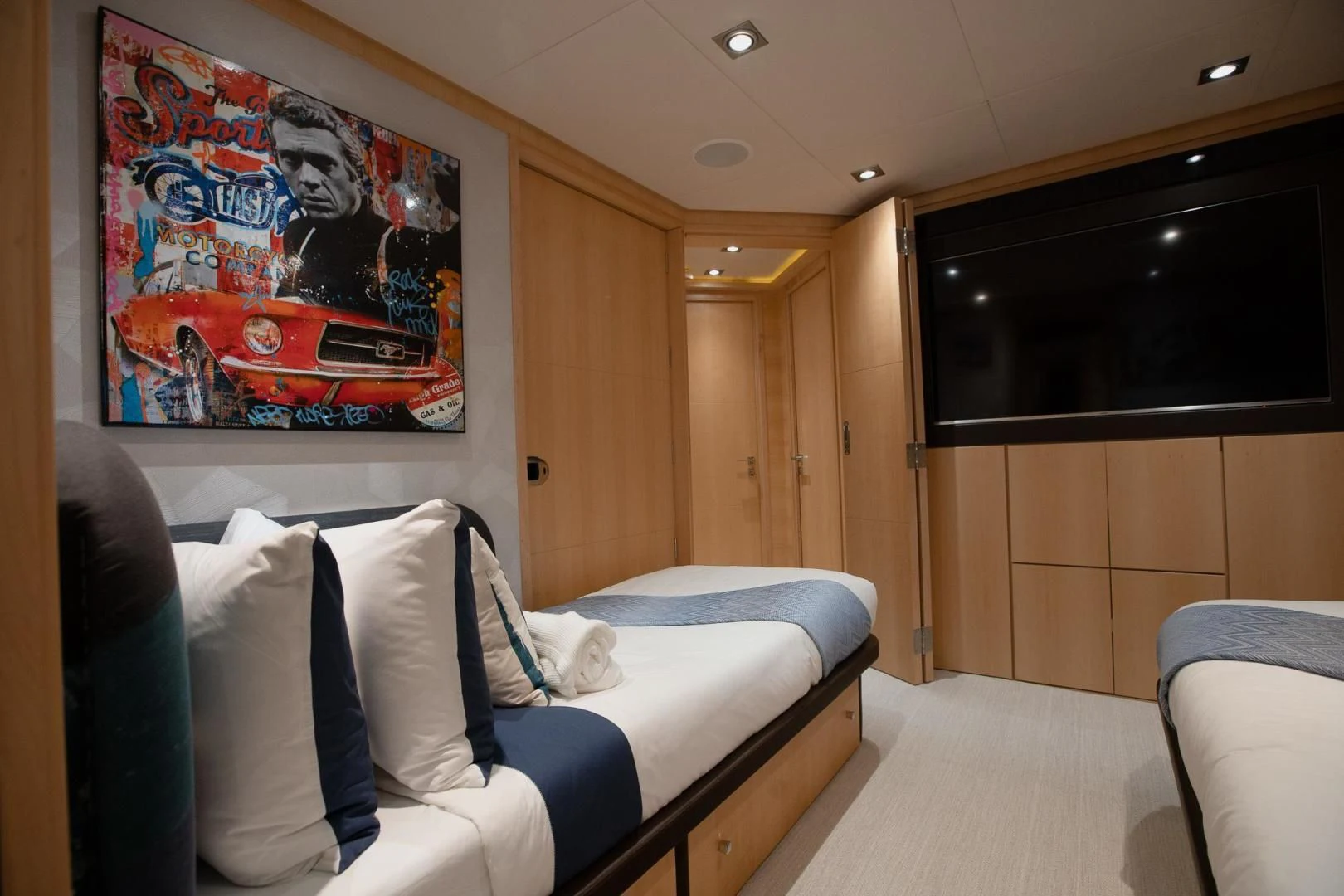 a room with a bed and a television aboard KJOS Yacht for Charter