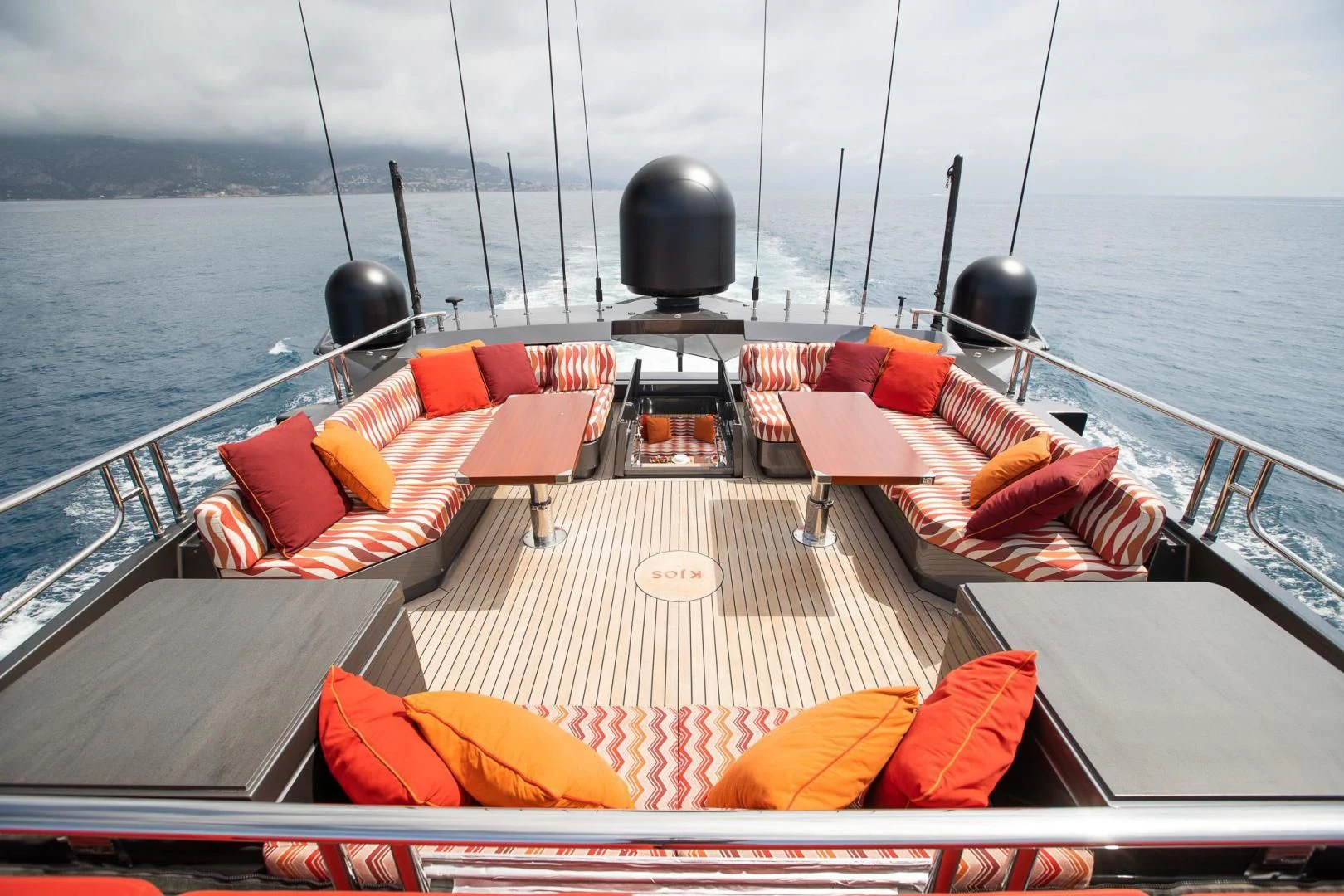 a deck with a boat and chairs aboard KJOS Yacht for Charter