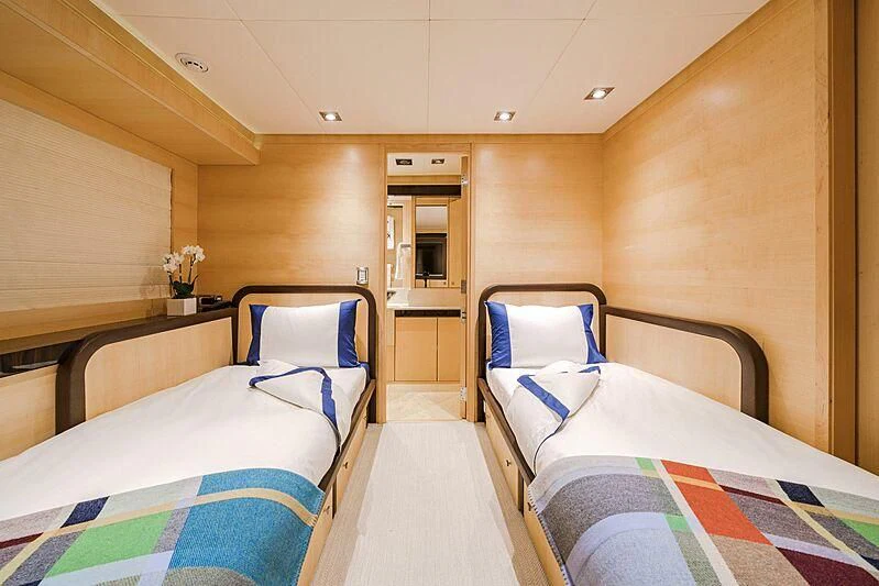 a room with beds and a door aboard KJOS Yacht for Charter