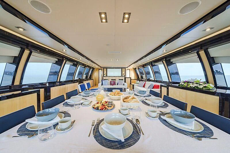 a large dining room with a large table set for a meal aboard KJOS Yacht for Charter