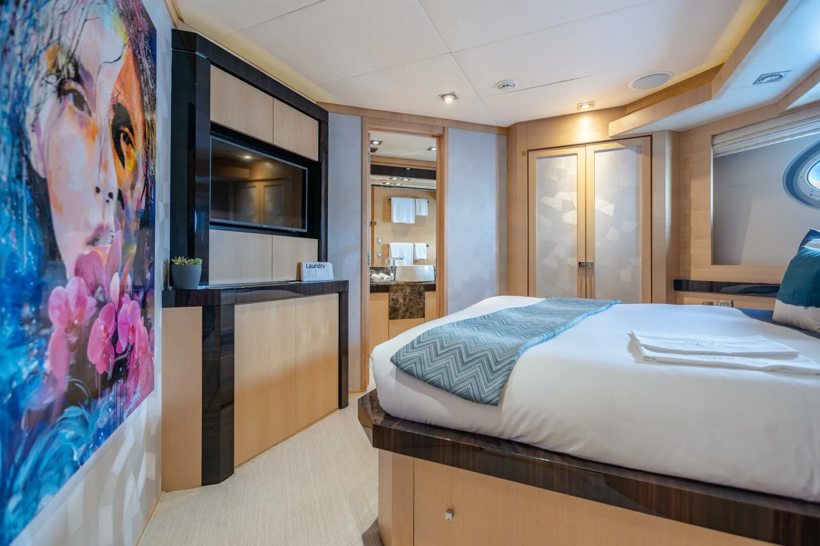 a bedroom with a large painting aboard KJOS Yacht for Charter
