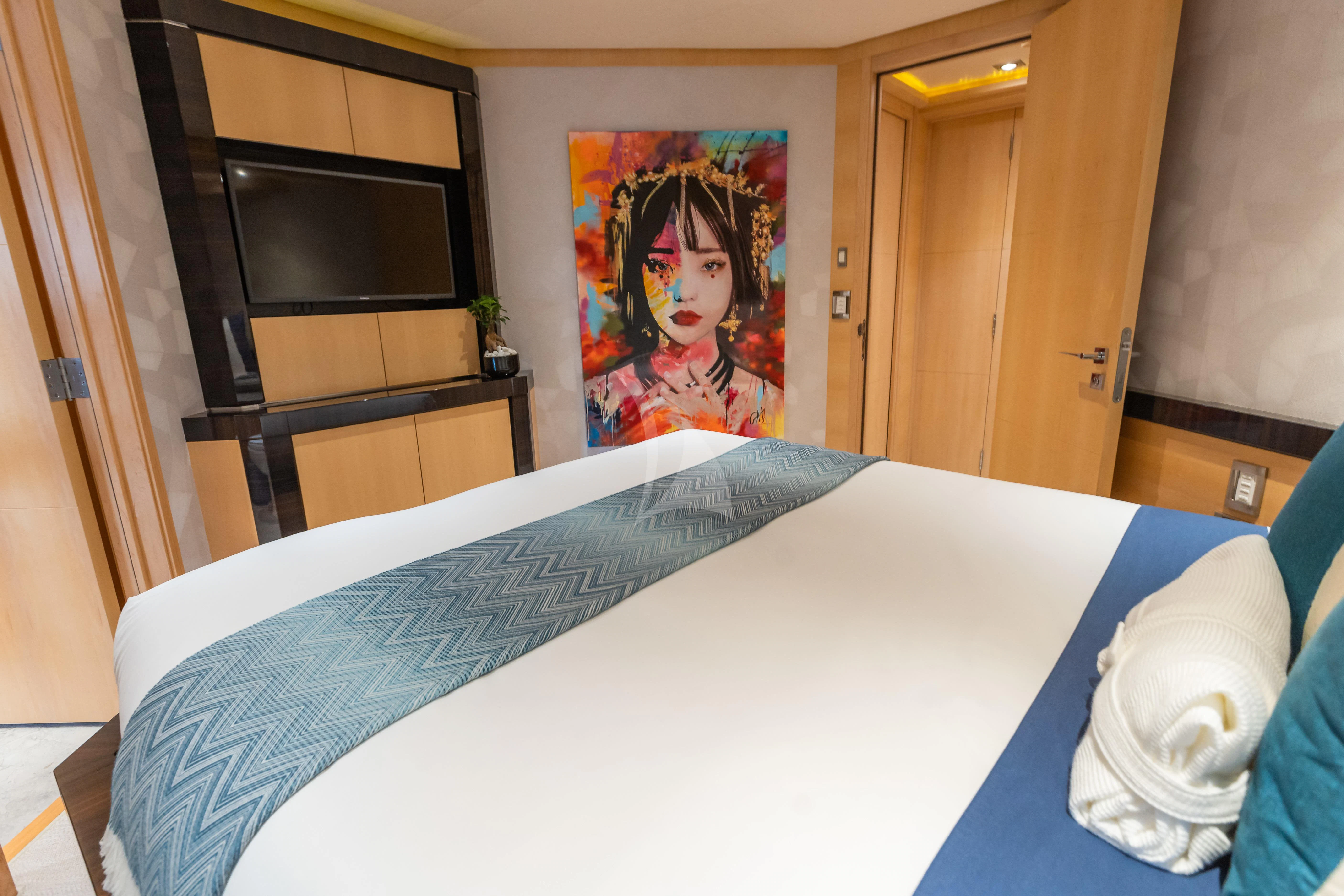 a bed with a painting on the wall aboard KJOS Yacht for Charter