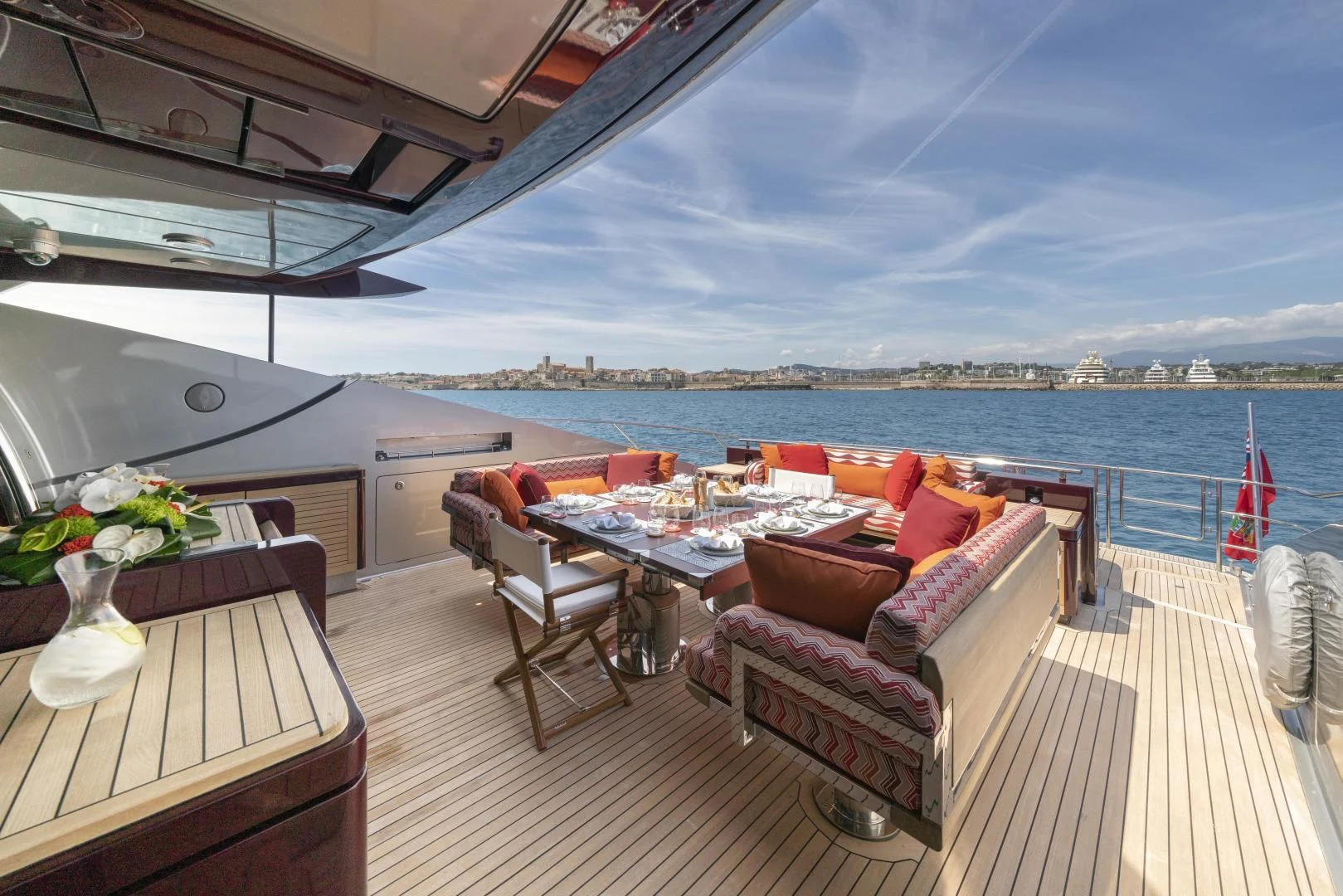 a deck with a table and chairs on it aboard KJOS Yacht for Charter