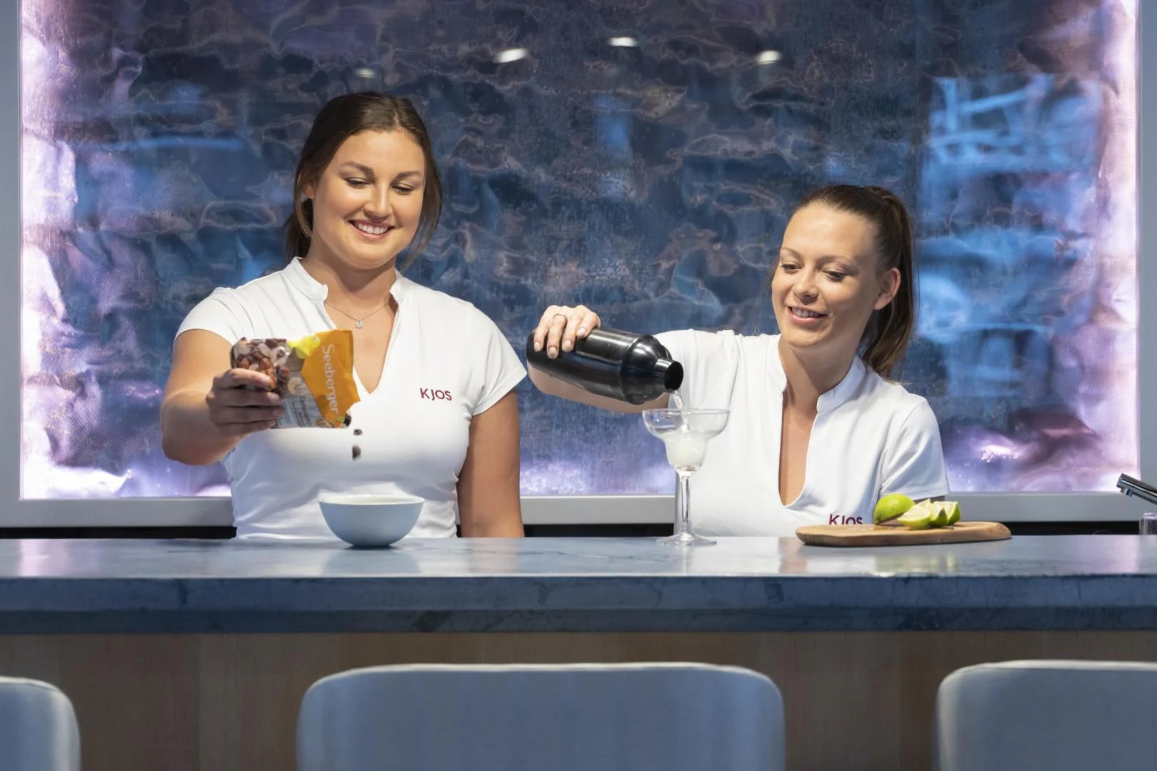 a couple of women sitting at a table with food and drinks aboard KJOS Yacht for Charter