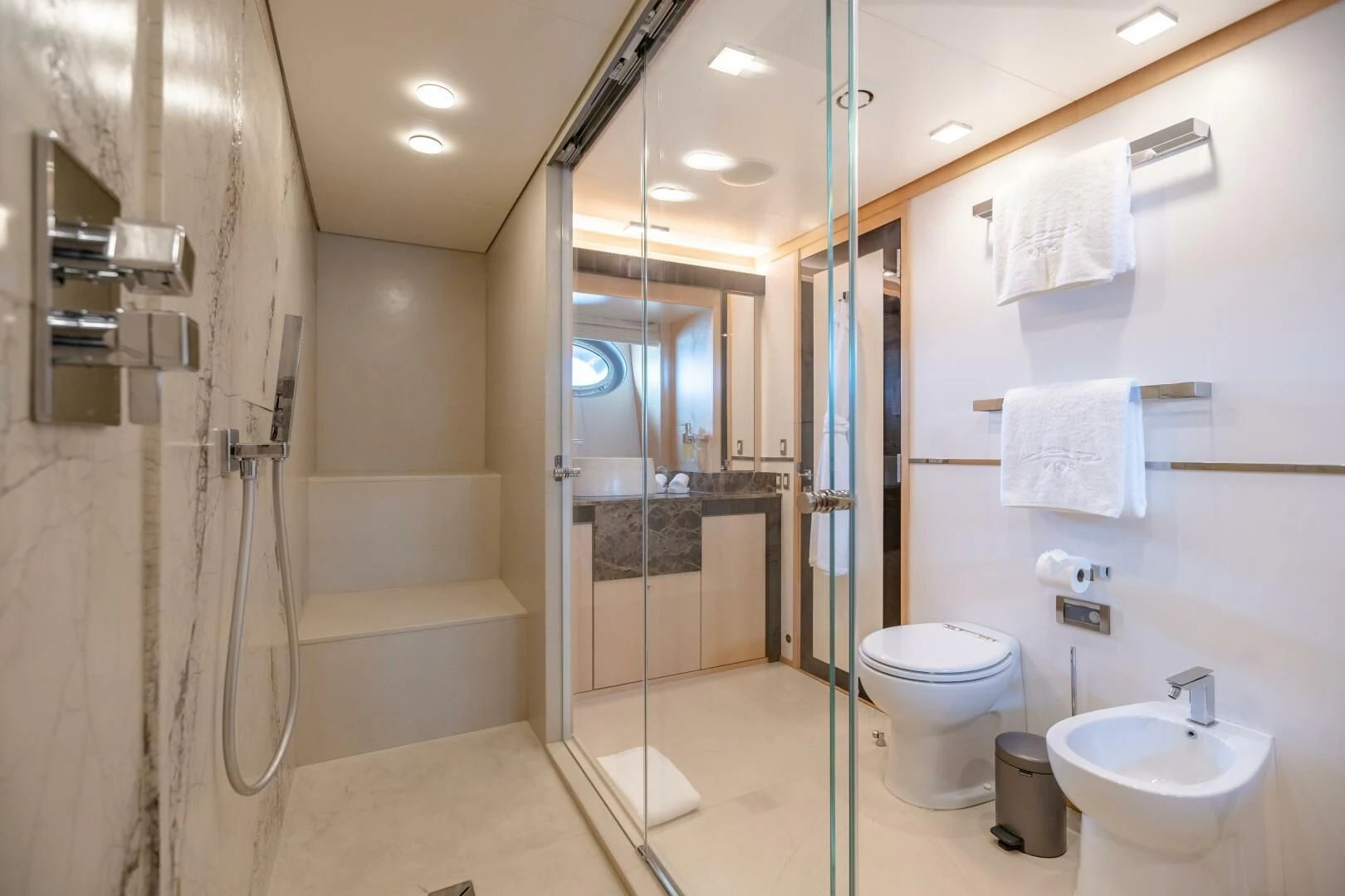 a bathroom with a glass shower aboard KJOS Yacht for Charter