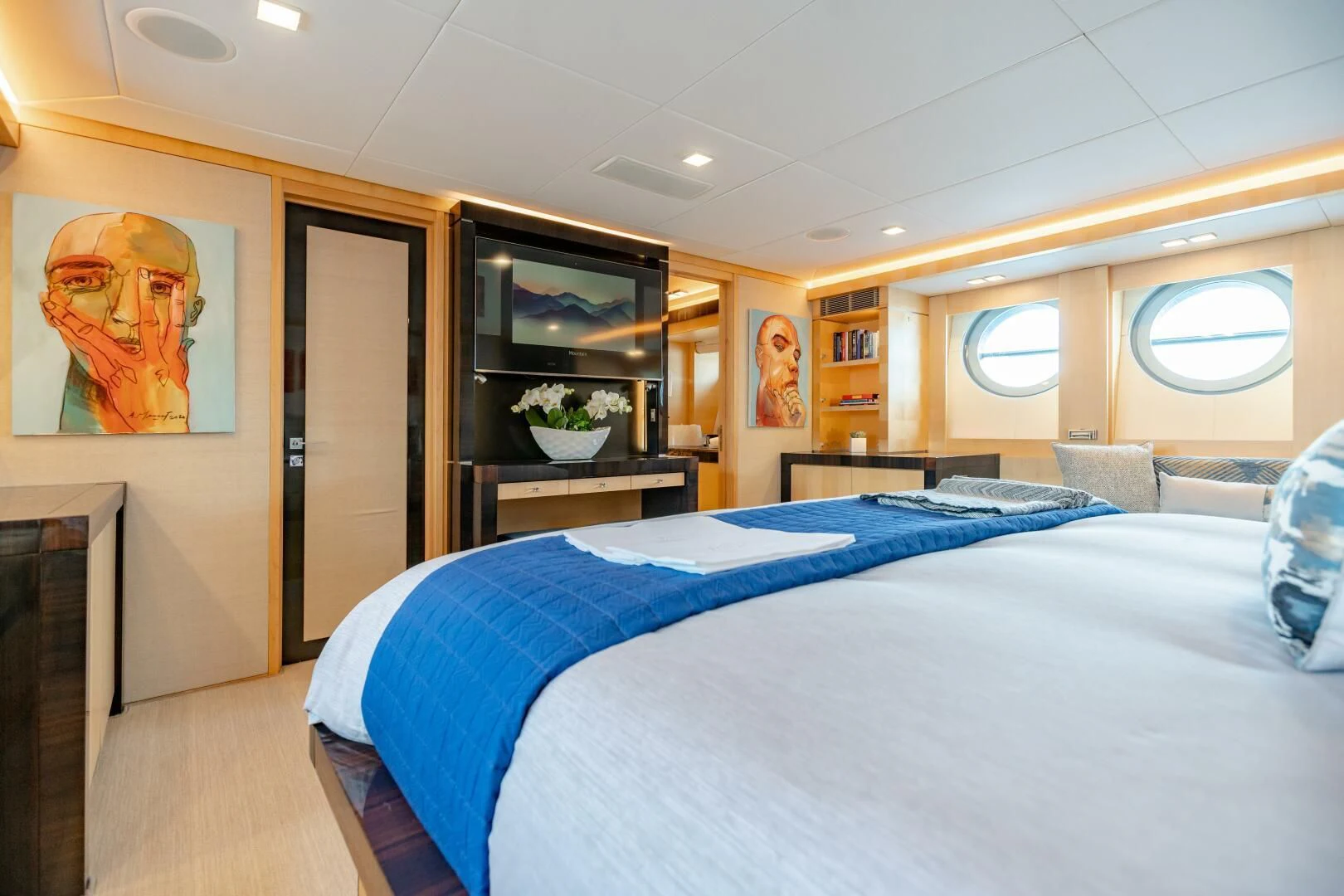 a bedroom with a bed and a tv on the wall aboard KJOS Yacht for Charter