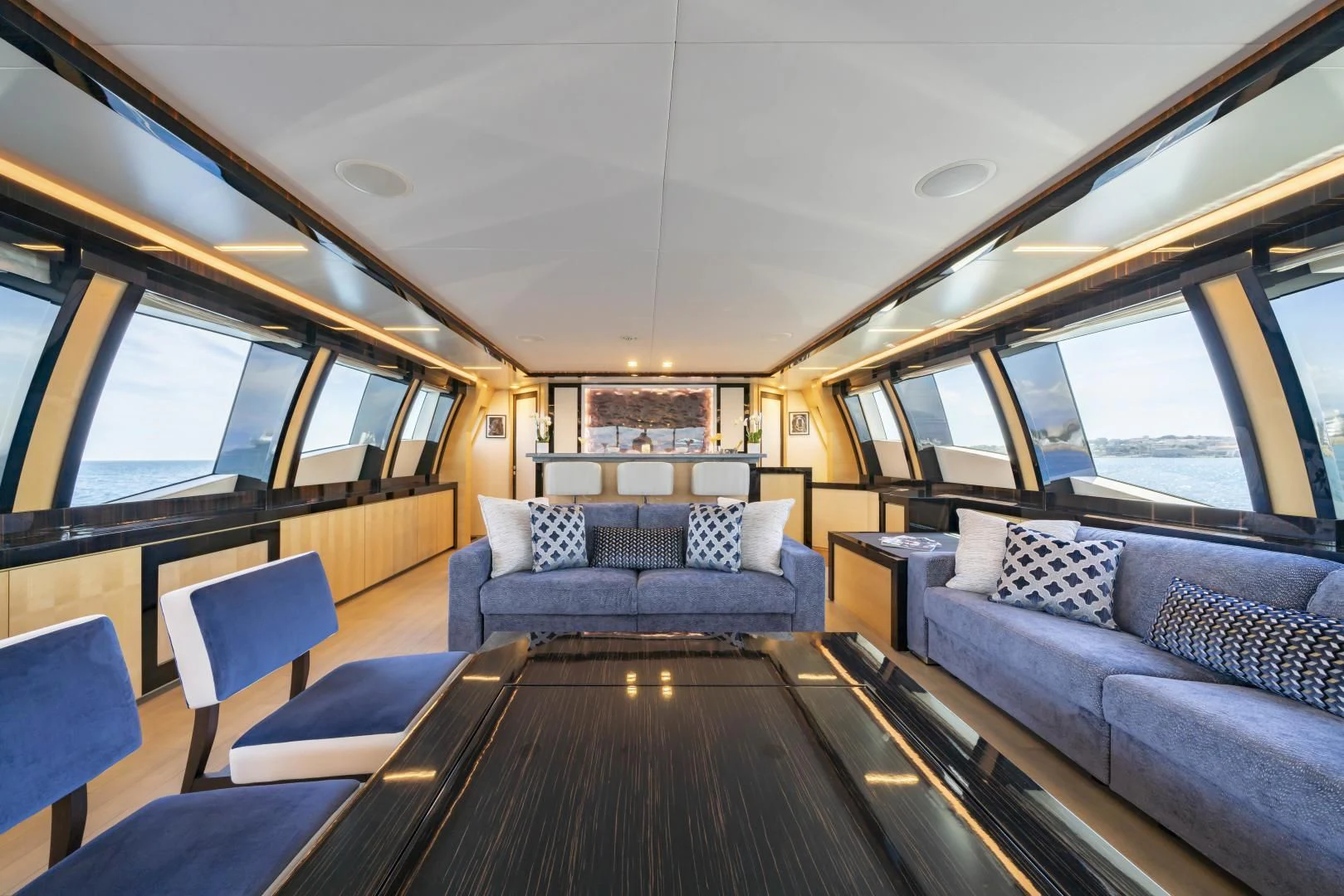 a large living room with a wood table and couches aboard KJOS Yacht for Charter