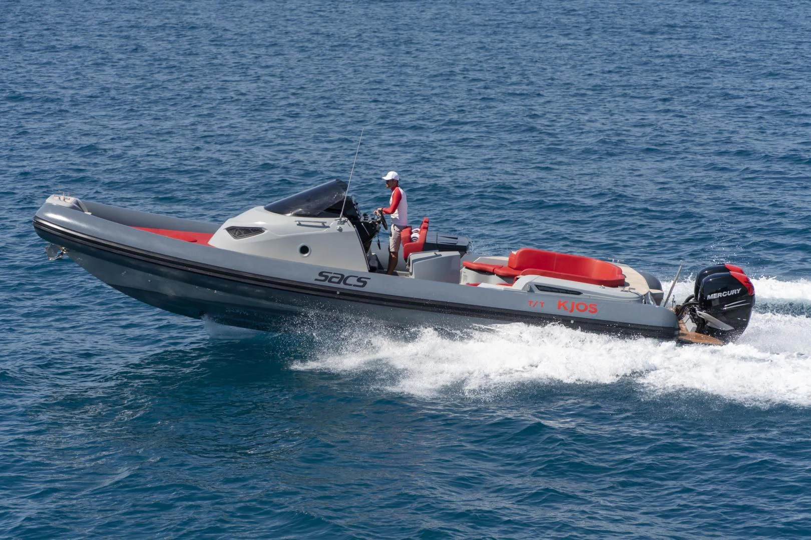 a person driving a speed boat aboard KJOS Yacht for Charter