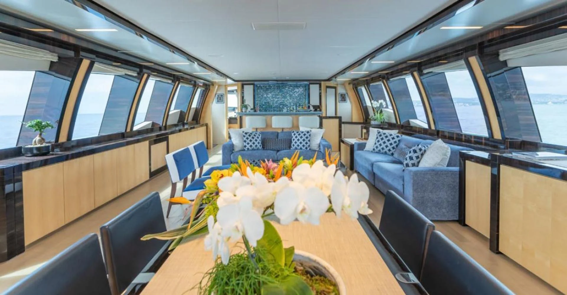 a room with a table chairs and flowers on the table aboard KJOS Yacht for Charter