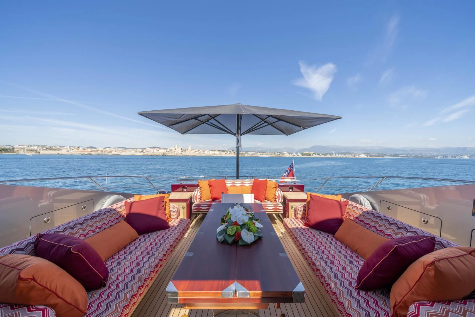 a patio with a table and chairs on it by the water aboard KJOS Yacht for Charter