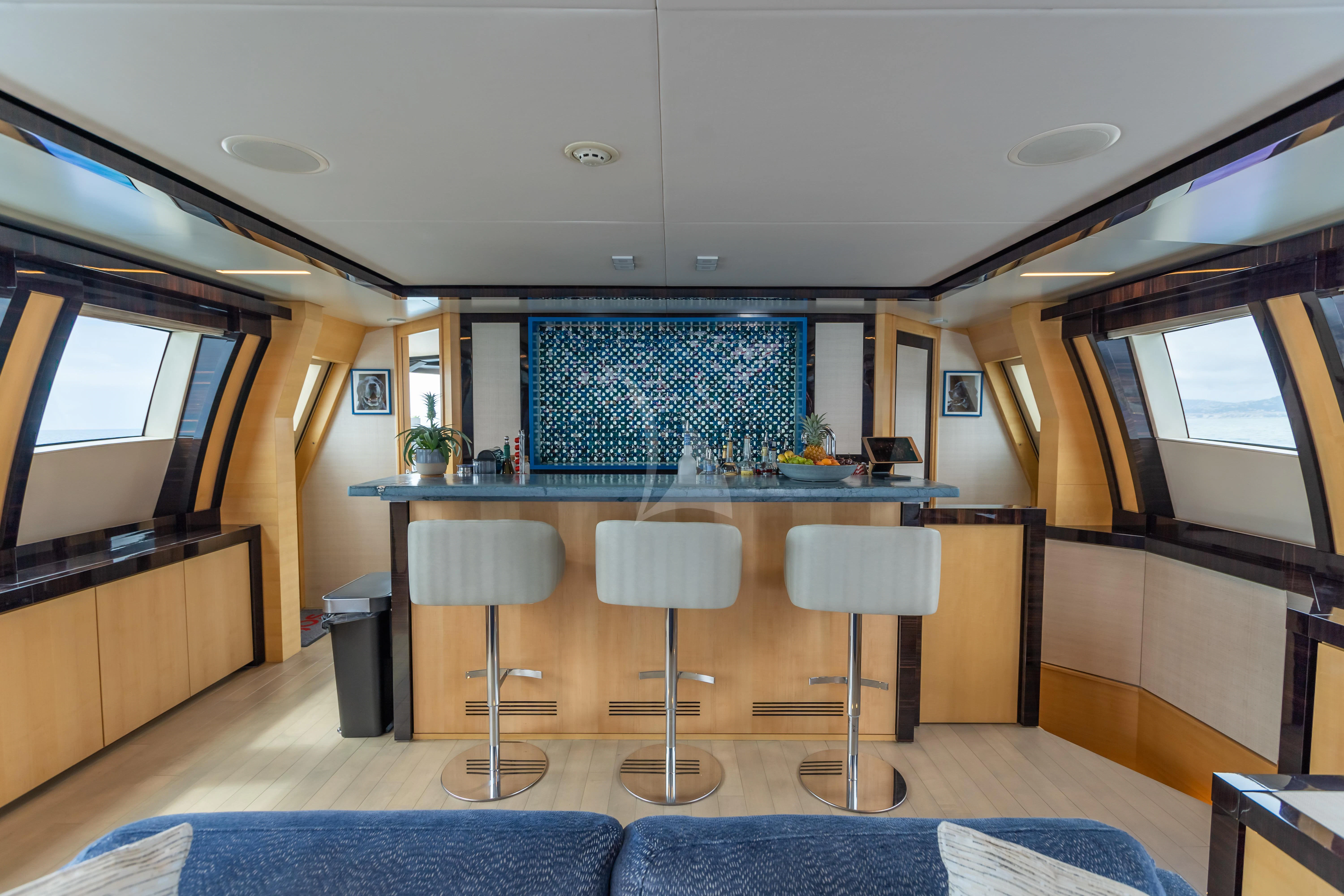 a large kitchen with a bar and bar stools aboard KJOS Yacht for Charter