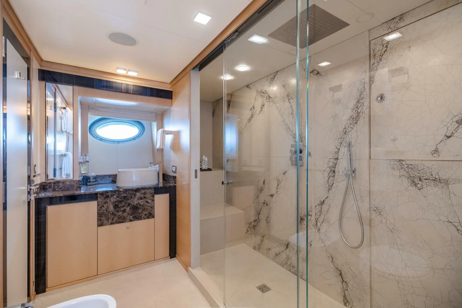 a bathroom with a glass shower aboard KJOS Yacht for Charter