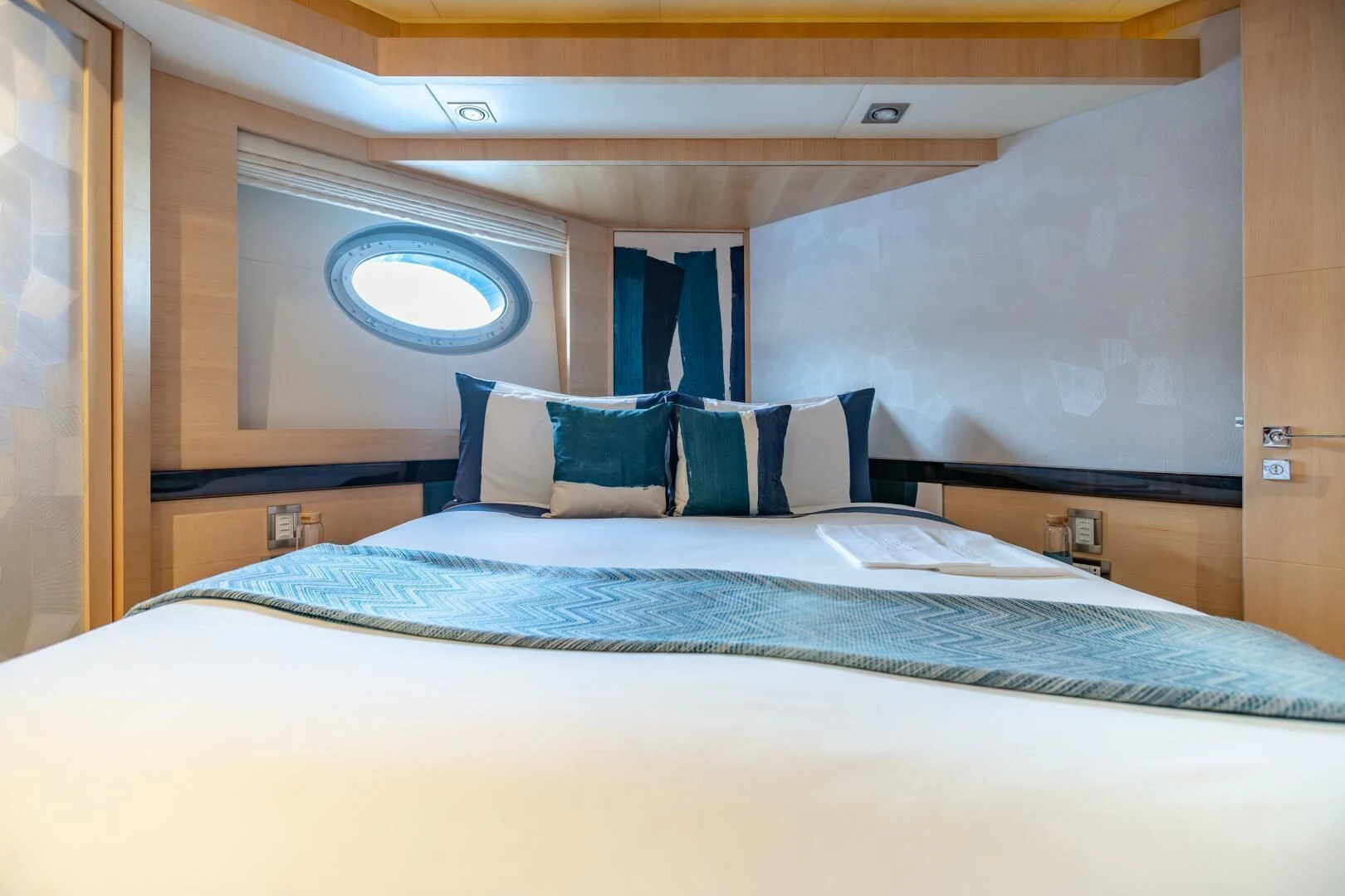 a bed with blue sheets aboard KJOS Yacht for Charter