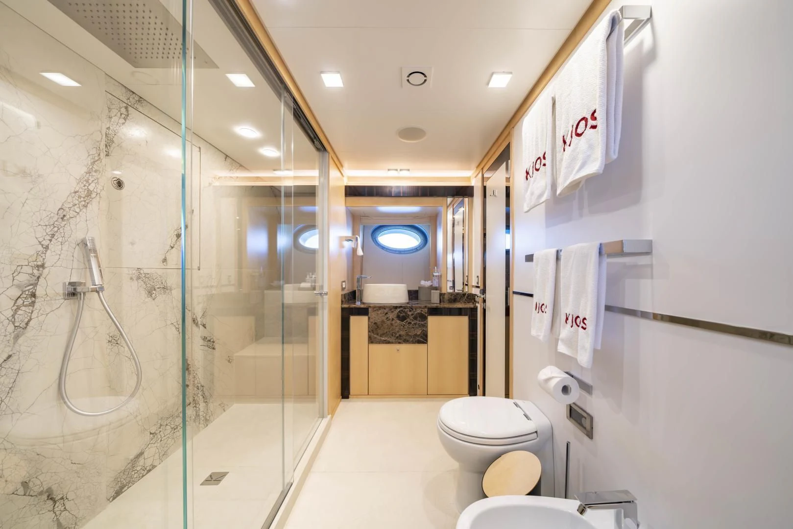 a bathroom with a glass shower aboard KJOS Yacht for Charter