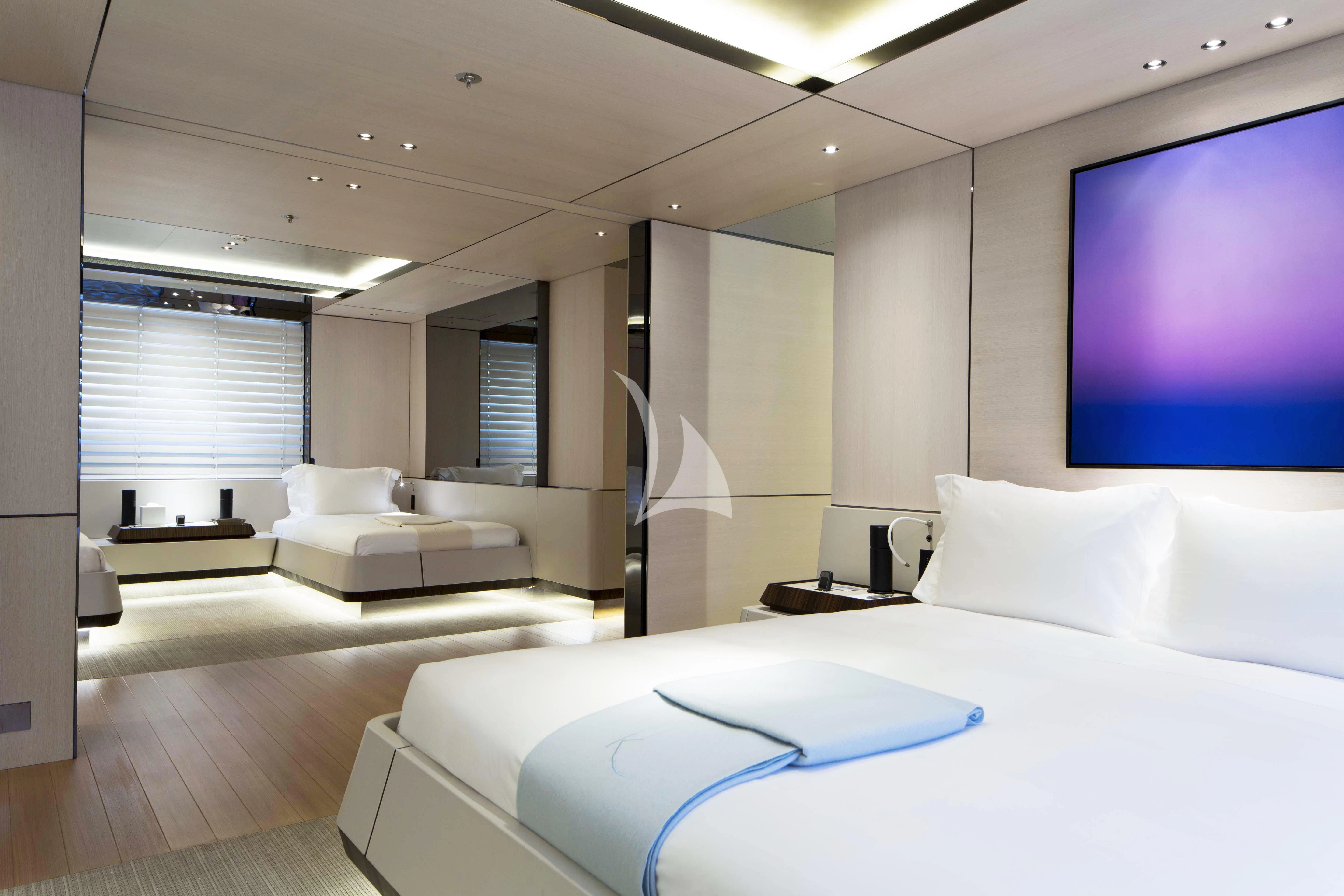 a room with a bed and a tv on the wall aboard KAMALAYA Yacht for Sale