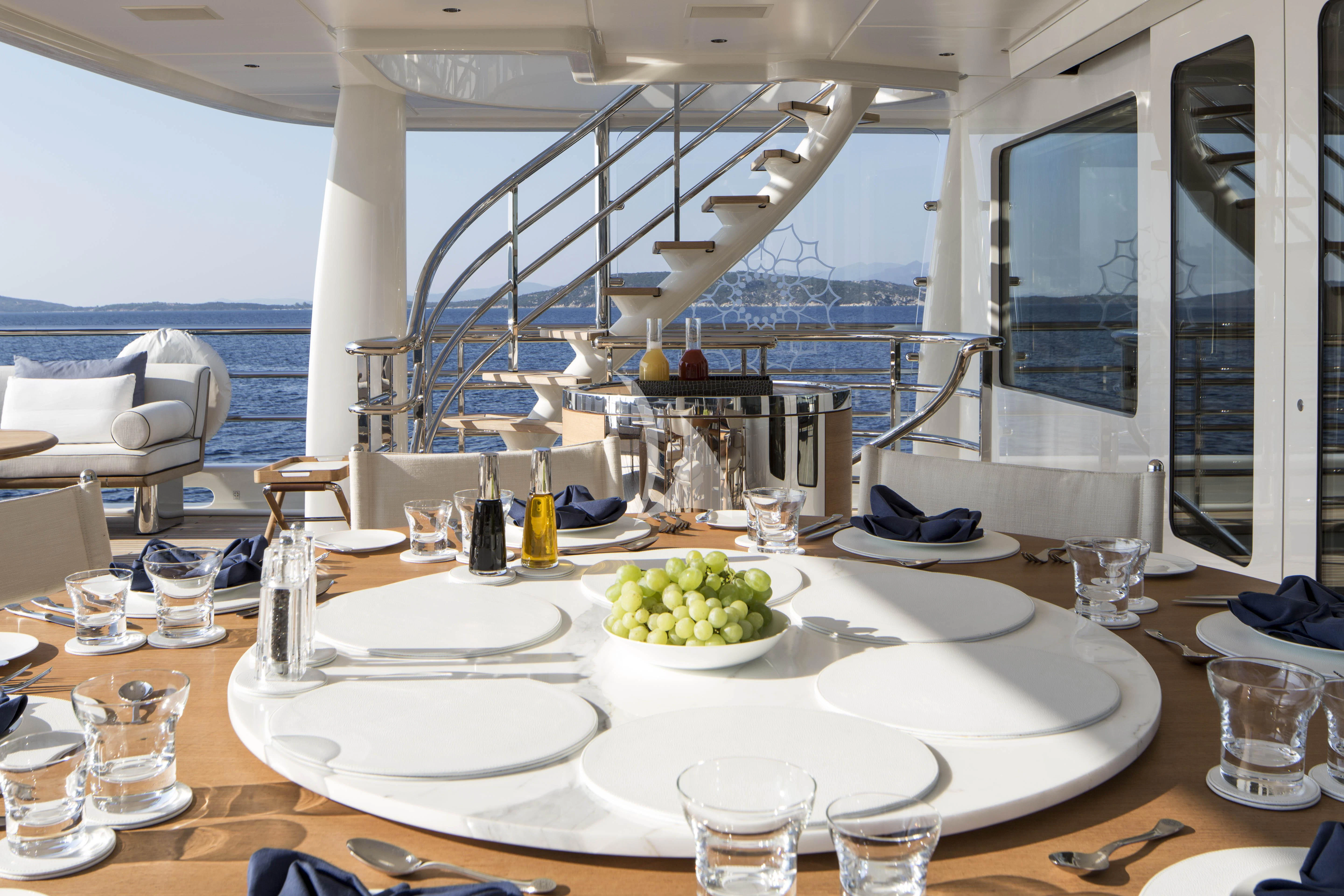 a table with plates and glasses on it aboard KAMALAYA Yacht for Sale